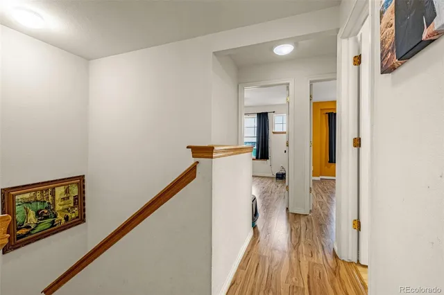 a view of a hallway with wooden floor and staircase