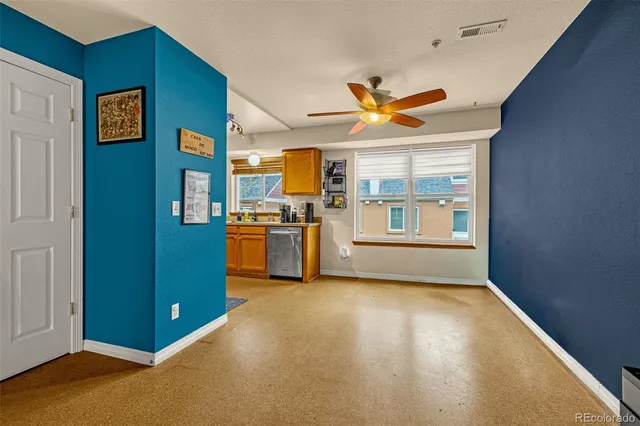 a living room with stainless steel appliances kitchen island granite countertop a refrigerator and a stove top oven