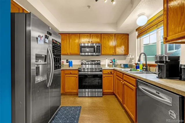 a kitchen with stainless steel appliances granite countertop a stove a sink and a refrigerator