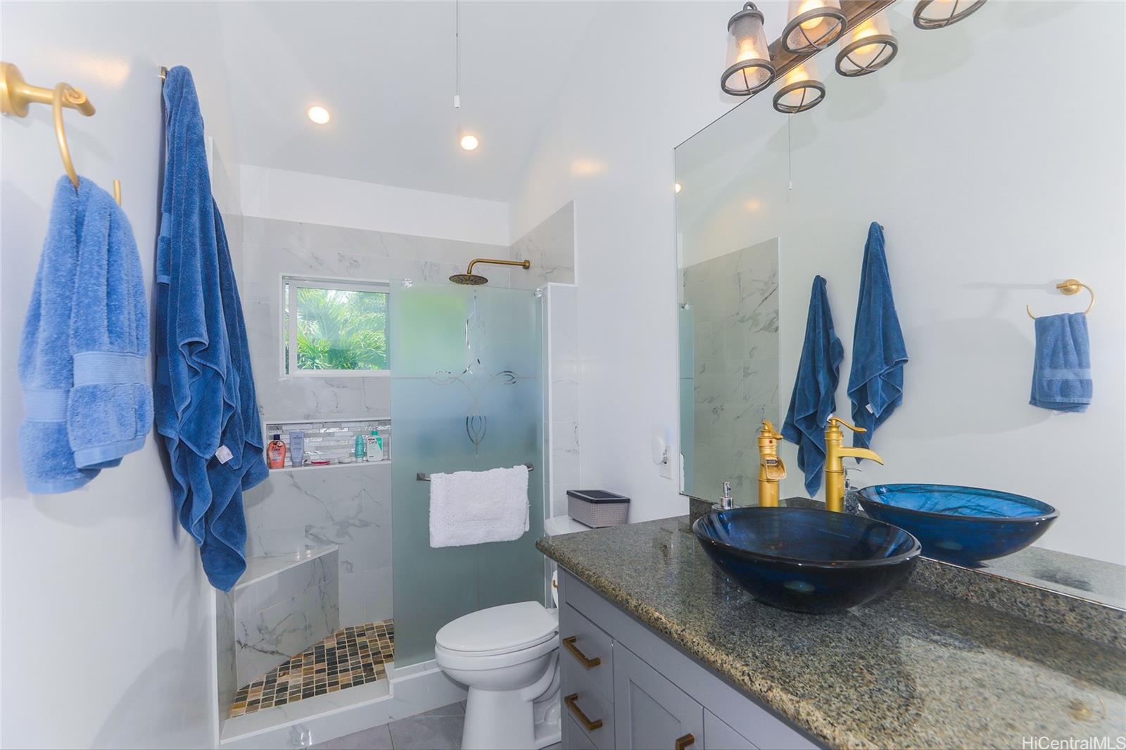 45-995 Wailele Road, Unit 8 Kaneohe, HI 96744 - Photo 19 of 25 Recently renovated primary featuring a tiled walk in shower, and newer vanity.