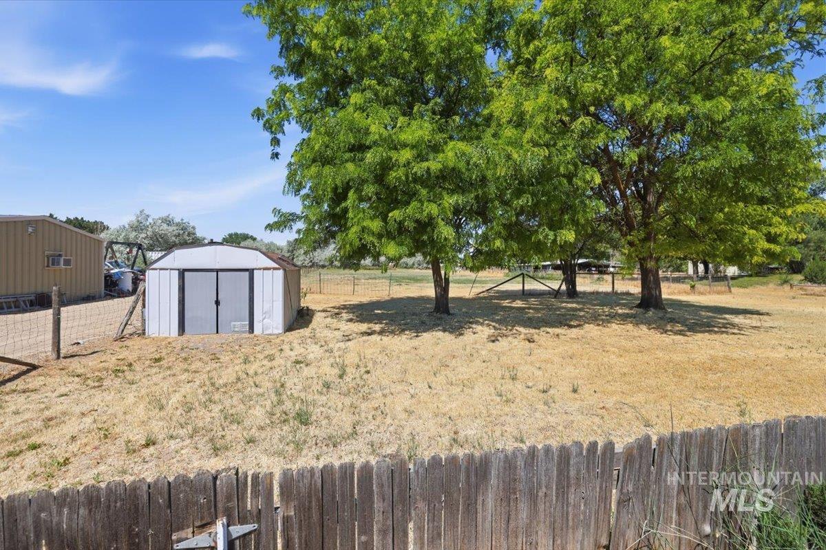 1311 North Middleton Road Nampa, ID 83651 - Photo 46 of 49 Expansive outdoor space featuring a wood fence, mature trees, and a freestanding storage shed