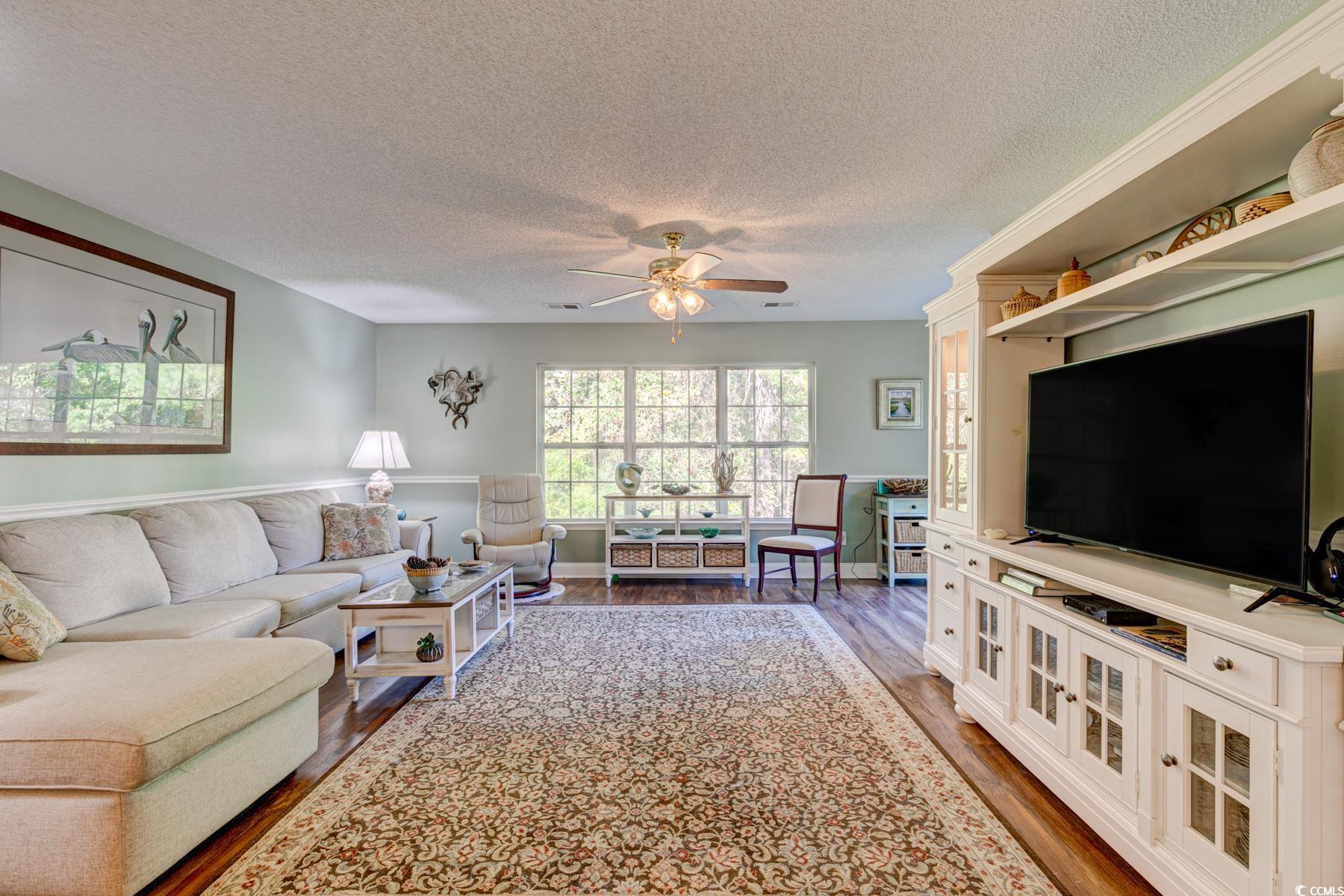 4840 Moss Creek Loop, Unit 36 Murrells Inlet, SC 29576 - Photo 21 of 37 Living area featuring a textured ceiling, dark wood-style floors, and a ceiling fan