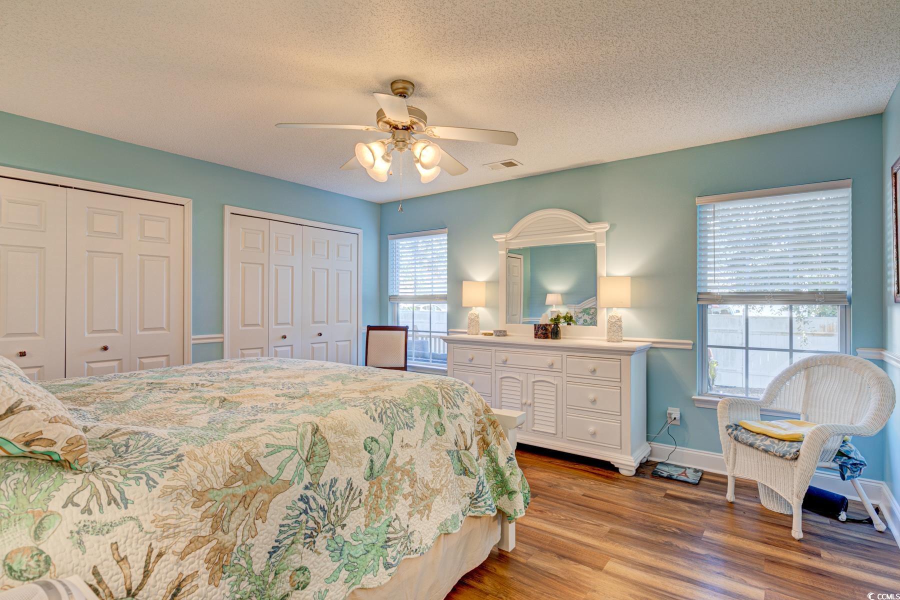 4840 Moss Creek Loop, Unit 36 Murrells Inlet, SC 29576 - Photo 22 of 37 Bedroom with multiple closets, light wood-style flooring, a textured ceiling, and a ceiling fan