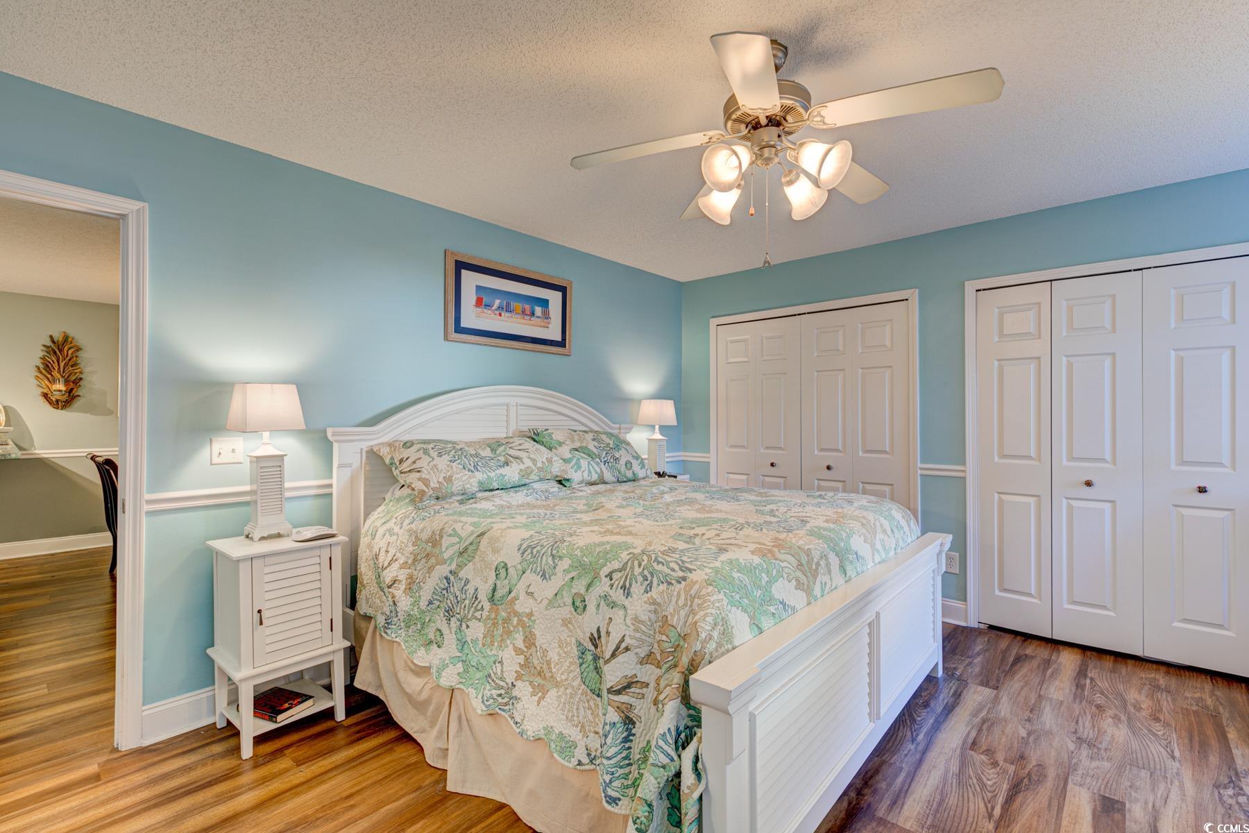 4840 Moss Creek Loop, Unit 36 Murrells Inlet, SC 29576 - Photo 23 of 37 Bedroom featuring multiple closets, wood finished floors, a textured ceiling, and a ceiling fan