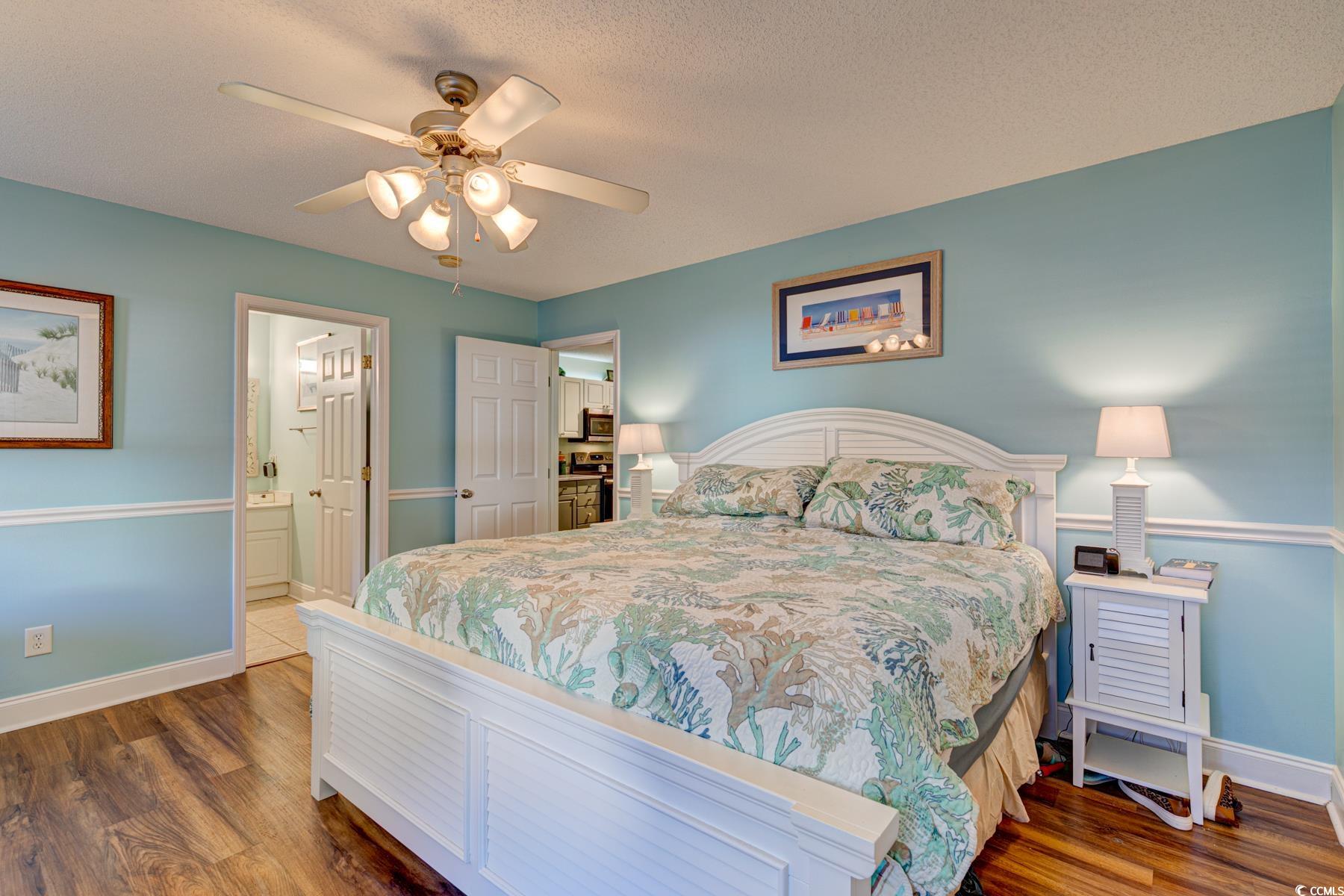 4840 Moss Creek Loop, Unit 36 Murrells Inlet, SC 29576 - Photo 25 of 37 Bedroom with a textured ceiling, wood finished floors, ceiling fan, and ensuite bath
