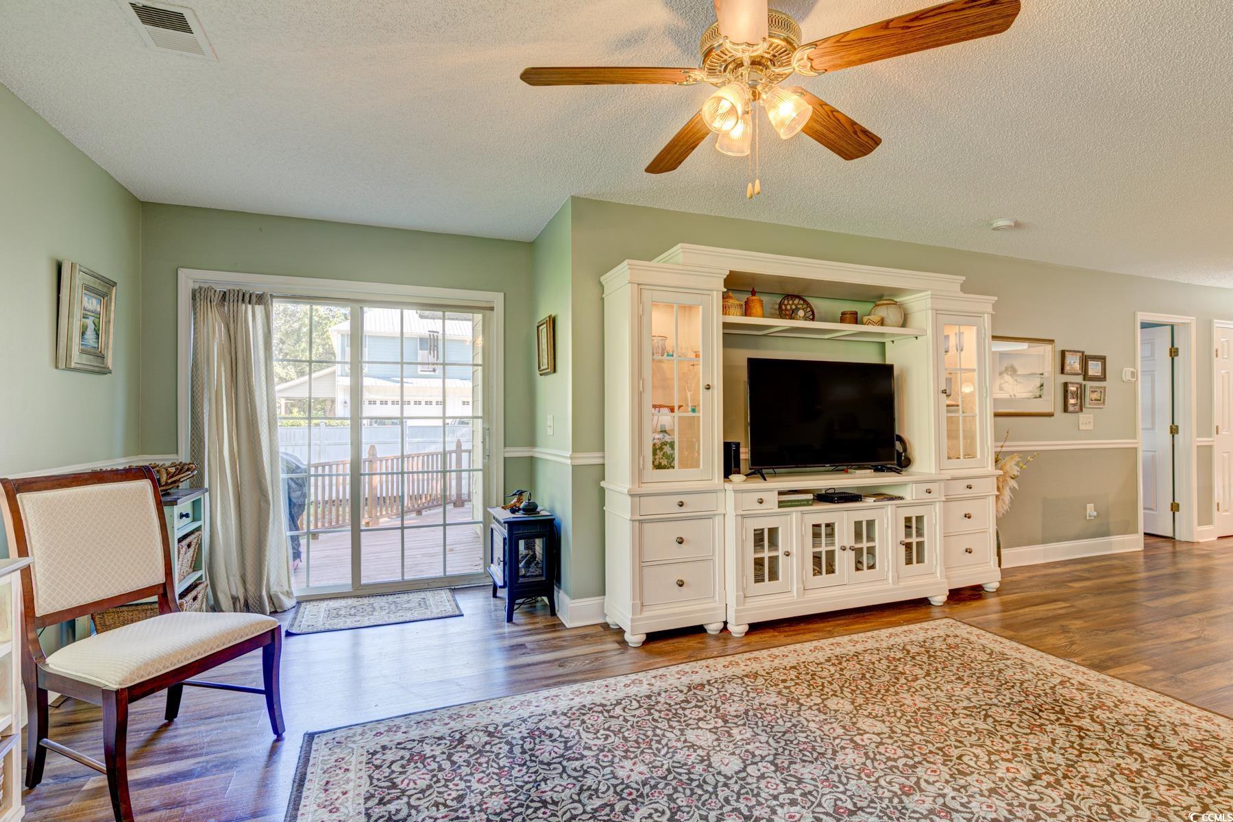 4840 Moss Creek Loop, Unit 36 Murrells Inlet, SC 29576 - Photo 29 of 37 Living area with dark wood-type flooring, a textured ceiling, and ceiling fan