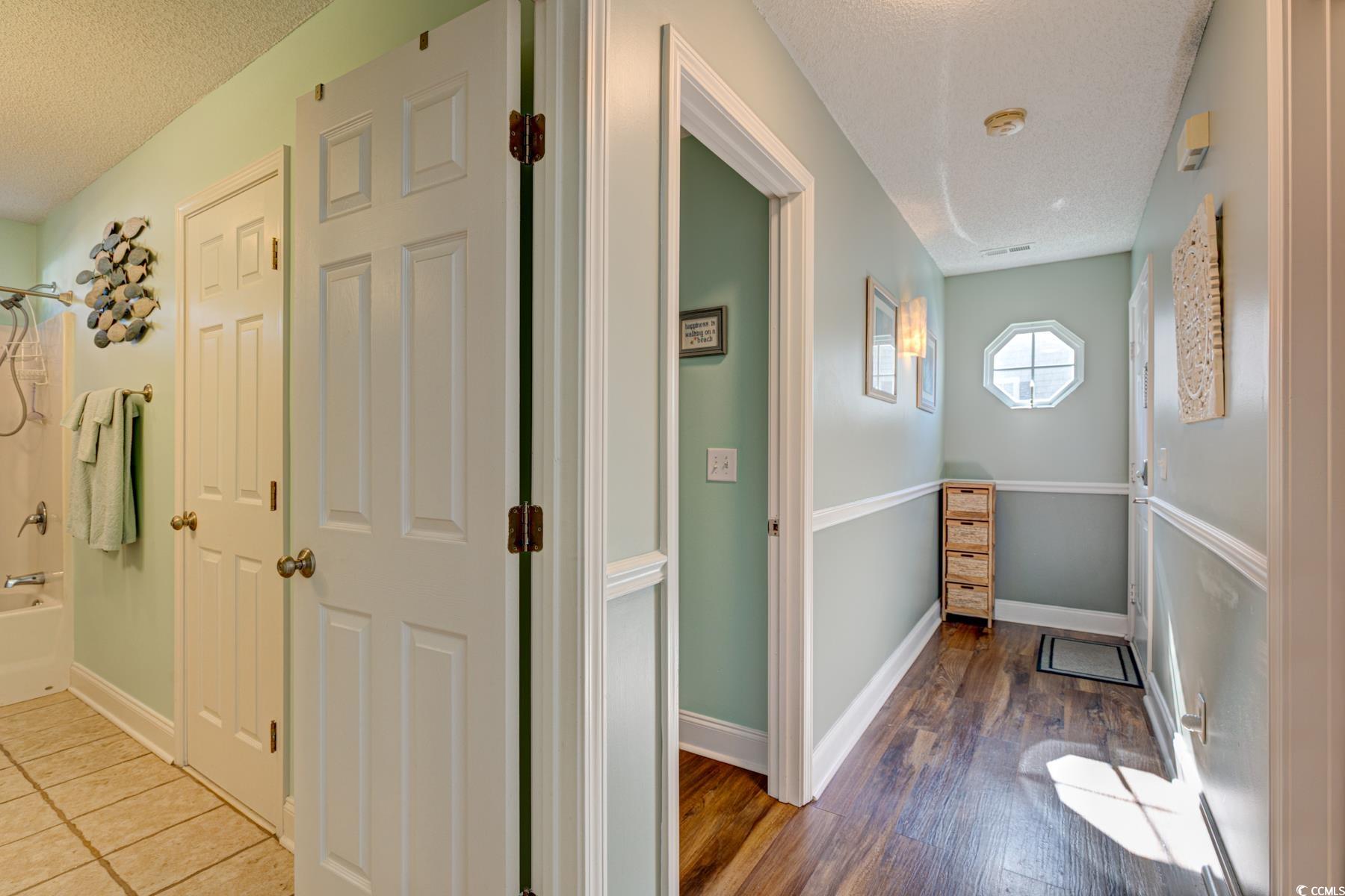 4840 Moss Creek Loop, Unit 36 Murrells Inlet, SC 29576 - Photo 3 of 37 Corridor featuring a textured ceiling and dark wood-type flooring