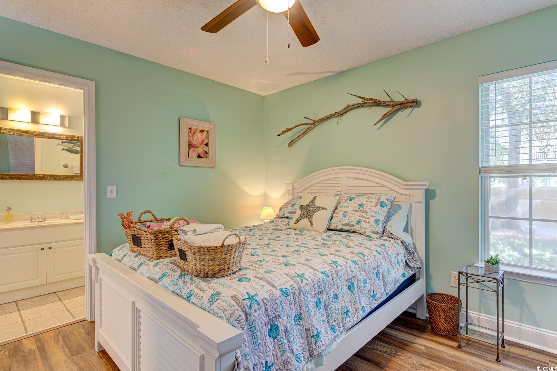 4840 Moss Creek Loop, Unit 36 Murrells Inlet, SC 29576 - Photo 5 of 37 Bedroom featuring light wood-style flooring, ensuite bathroom, a textured ceiling, and ceiling fan