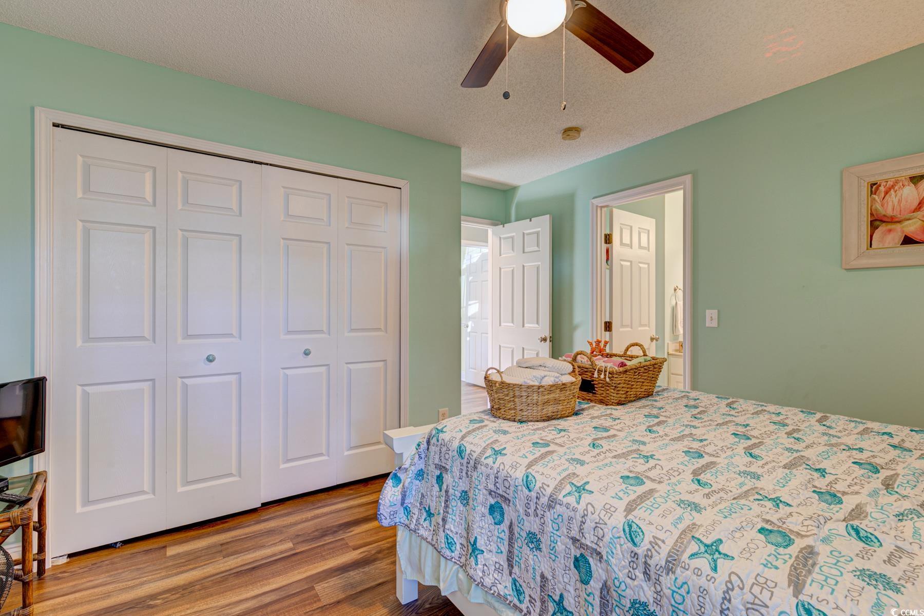 4840 Moss Creek Loop, Unit 36 Murrells Inlet, SC 29576 - Photo 6 of 37 Bedroom featuring a textured ceiling, wood finished floors, a ceiling fan, and a closet