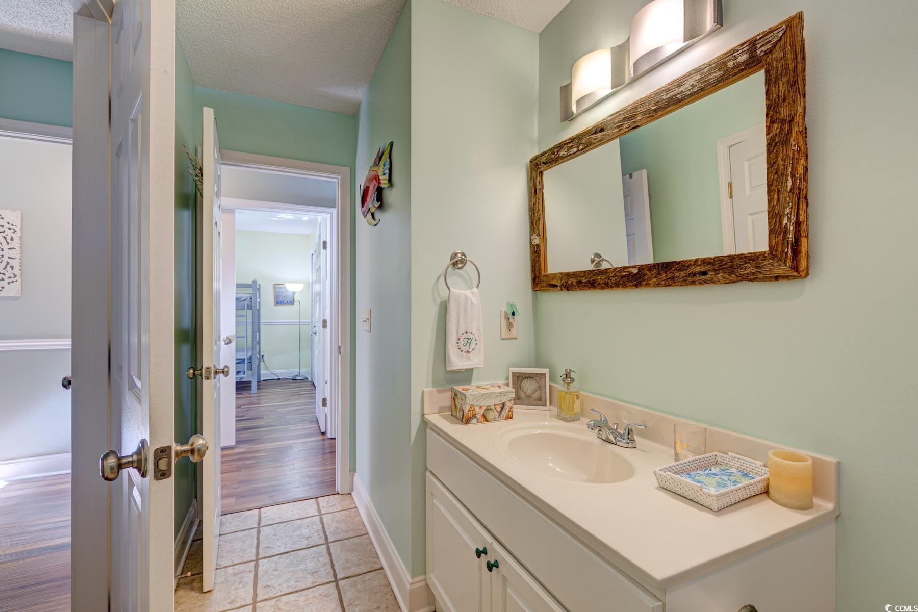 4840 Moss Creek Loop, Unit 36 Murrells Inlet, SC 29576 - Photo 8 of 37 Bathroom featuring vanity, light tile patterned flooring, and a textured ceiling