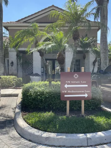 a view of a house with a small yard plants and large tree