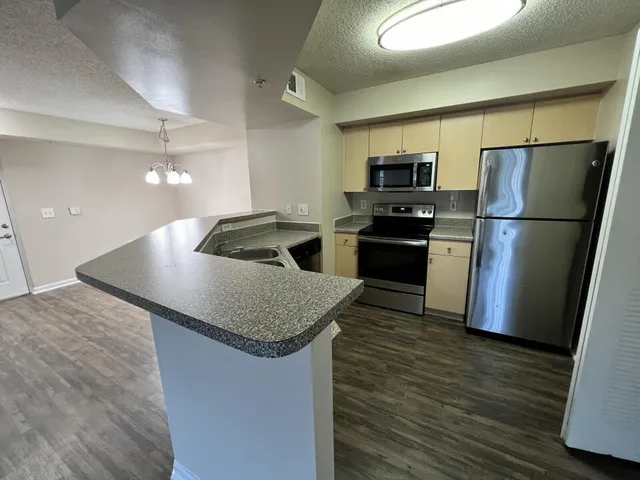 a kitchen with kitchen island a sink dishwasher a refrigerator and a stove