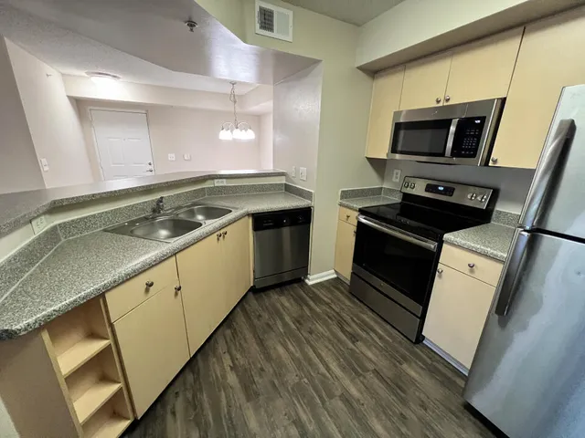 a kitchen with granite countertop a sink and steel appliances
