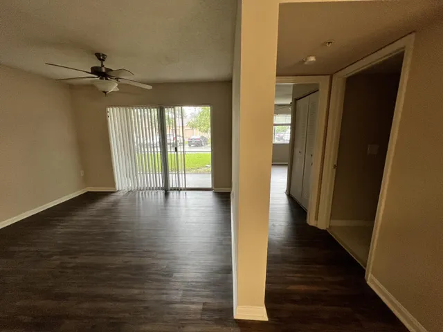 a view of a hallway with wooden floor and a ceiling fan