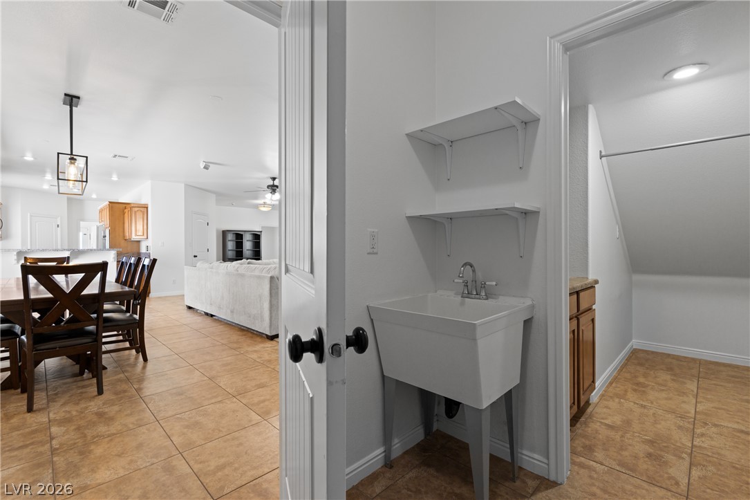 575 Gann Avenue Logandale, NV 89021 - Photo 29 of 75 A utilitarian laundry sink with shelving offers practical functionality within this home's versatile layout.