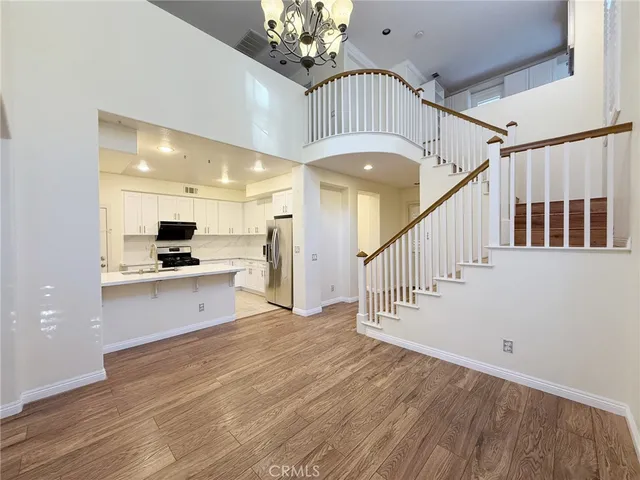 a view of front door with hallway and wooden floor