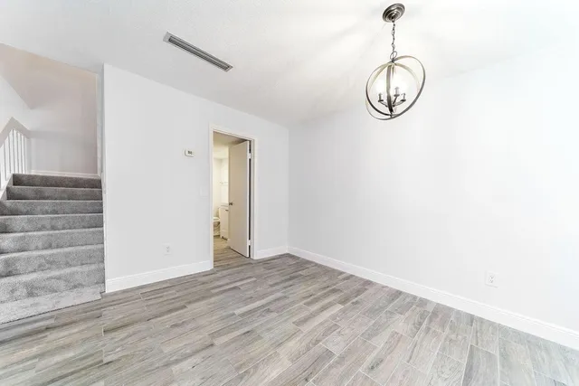 a view of a room with wooden floor and lots of windows