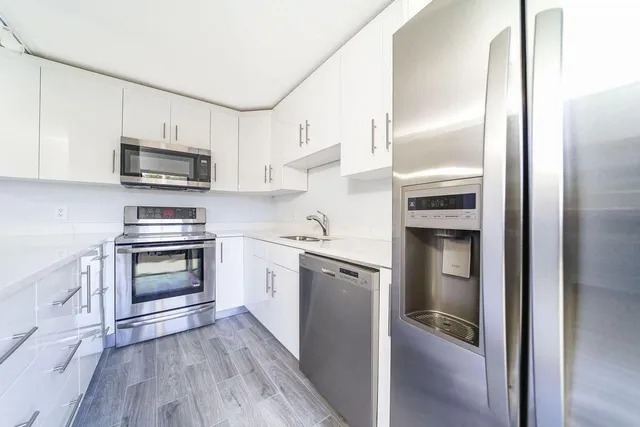 a kitchen with stainless steel appliances a stove sink and microwave