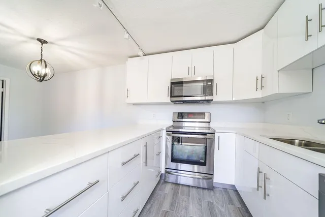 a kitchen with cabinets stainless steel appliances and a counter space