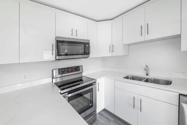 a kitchen with white cabinets and a stove top oven