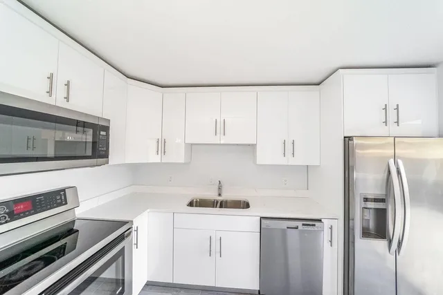 a kitchen with white cabinets and a stove top oven