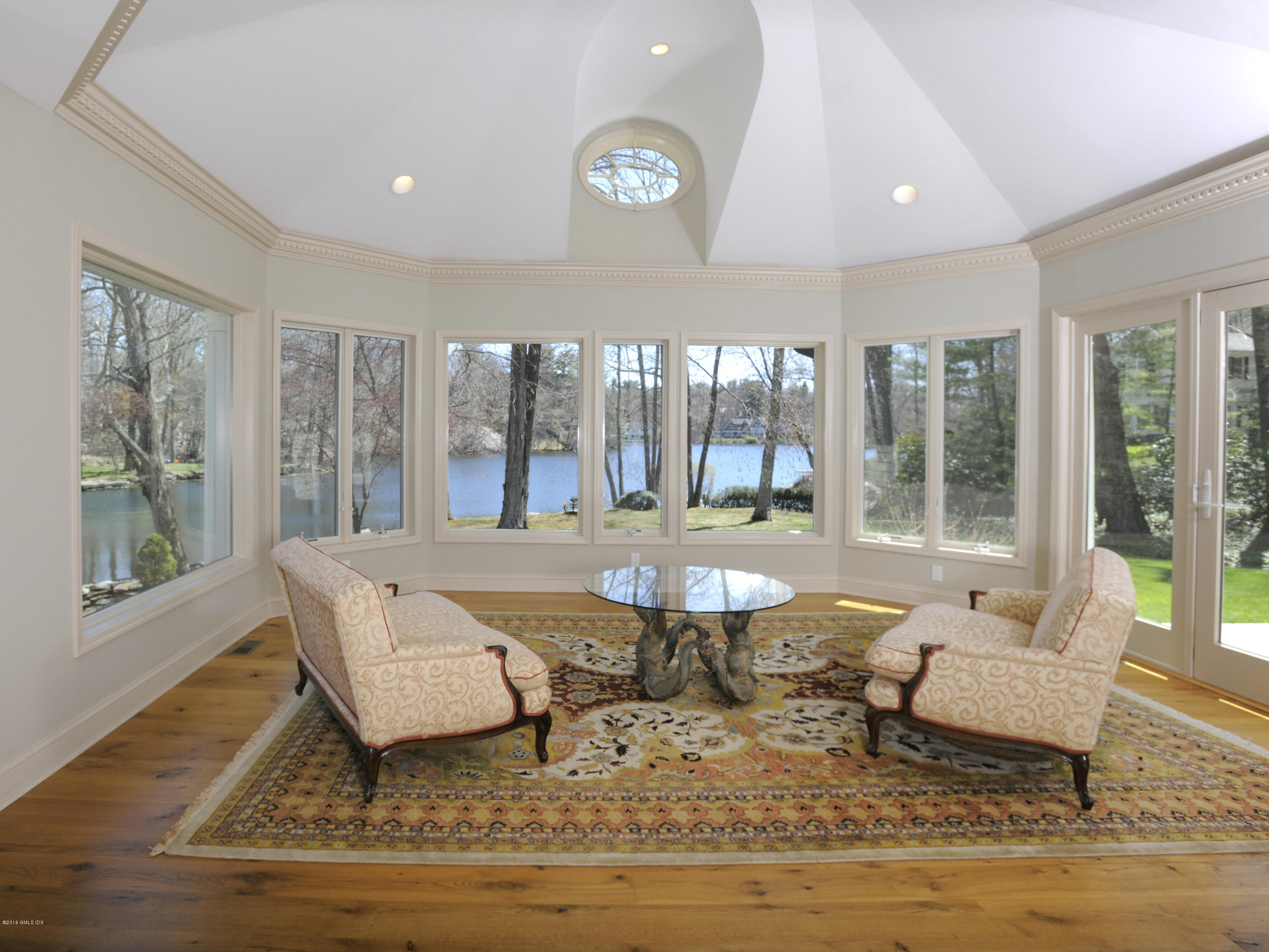 67 Burning Tree Road Greenwich, CT 06830 - Photo 11 of 28 a living room with furniture a rug potted plant and a large window