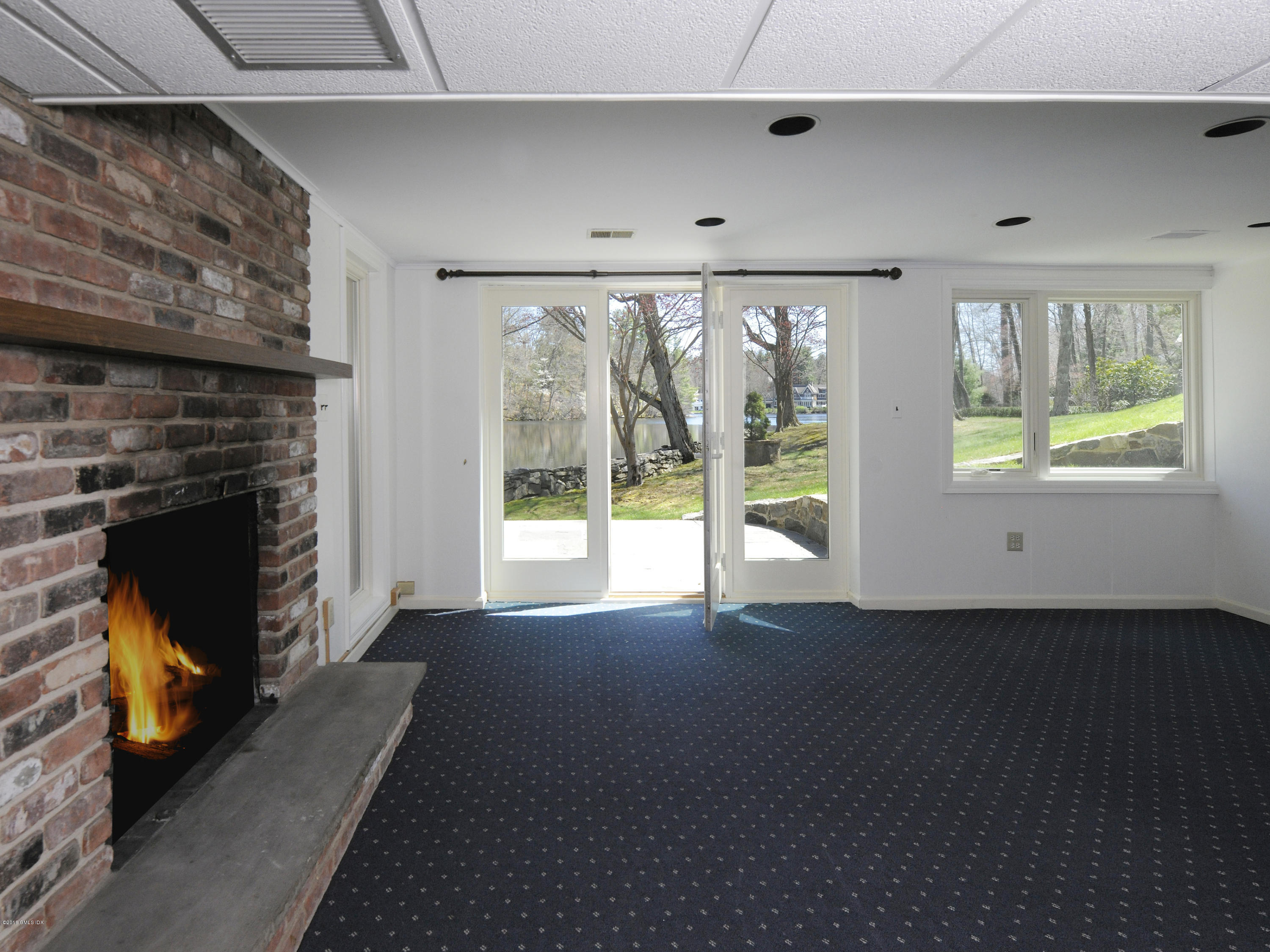 67 Burning Tree Road Greenwich, CT 06830 - Photo 17 of 28 a view of an empty room with a fireplace and a window