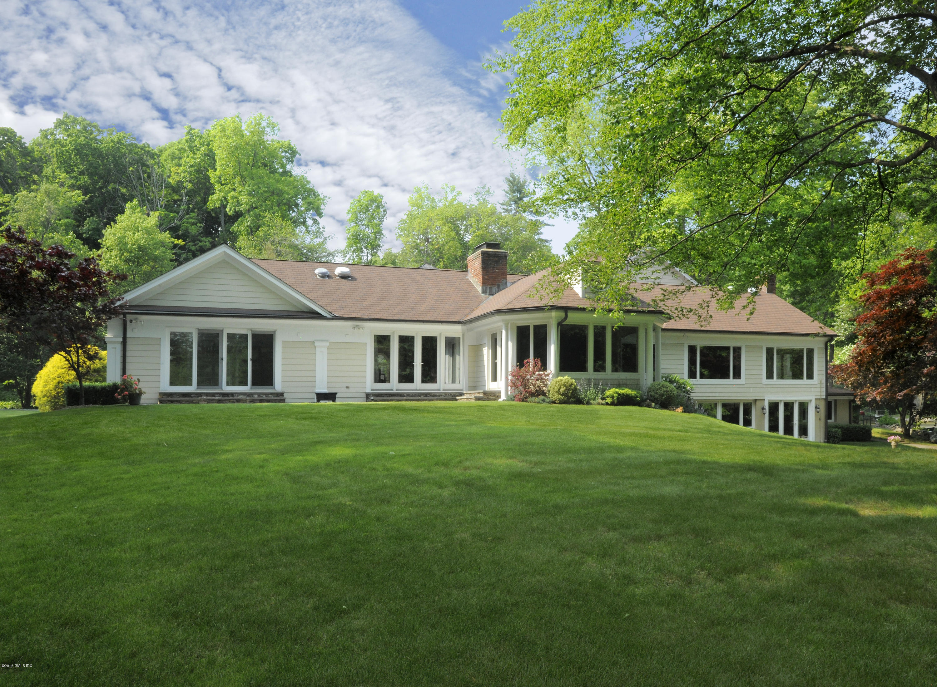 67 Burning Tree Road Greenwich, CT 06830 - Photo 24 of 28 a front view of a house with a garden