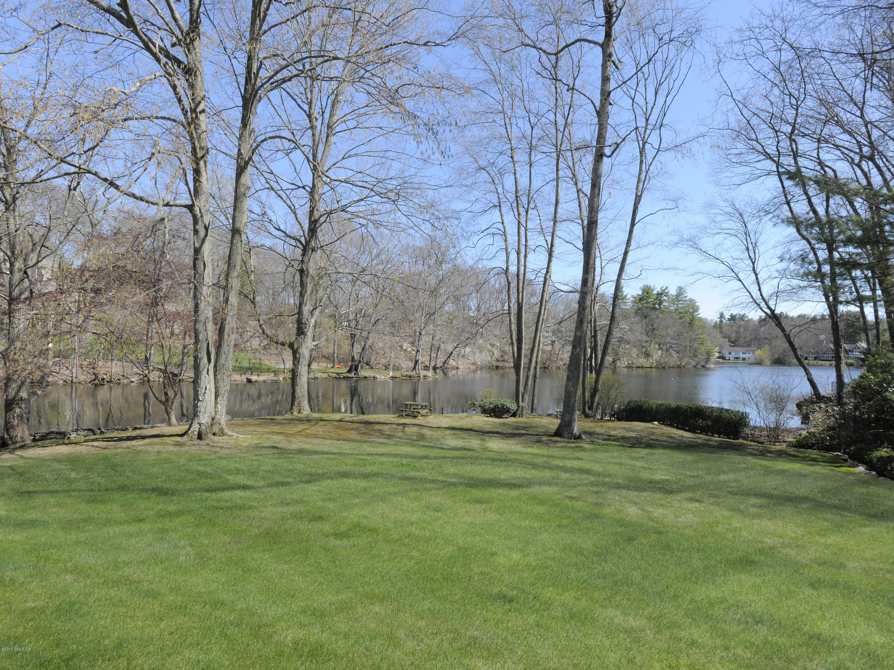 67 Burning Tree Road Greenwich, CT 06830 - Photo 27 of 28 a backyard of apartments with large trees