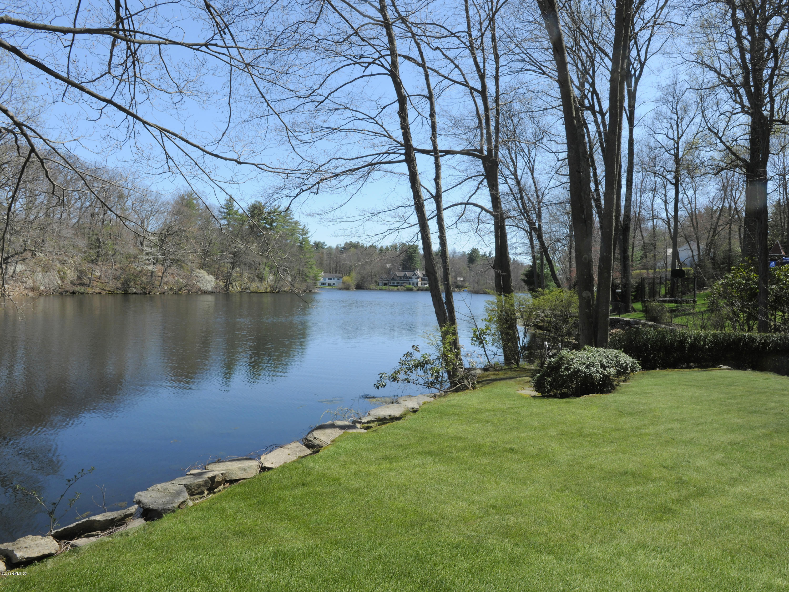 67 Burning Tree Road Greenwich, CT 06830 - Photo 28 of 28 a view of a lake with a yard and a fountain