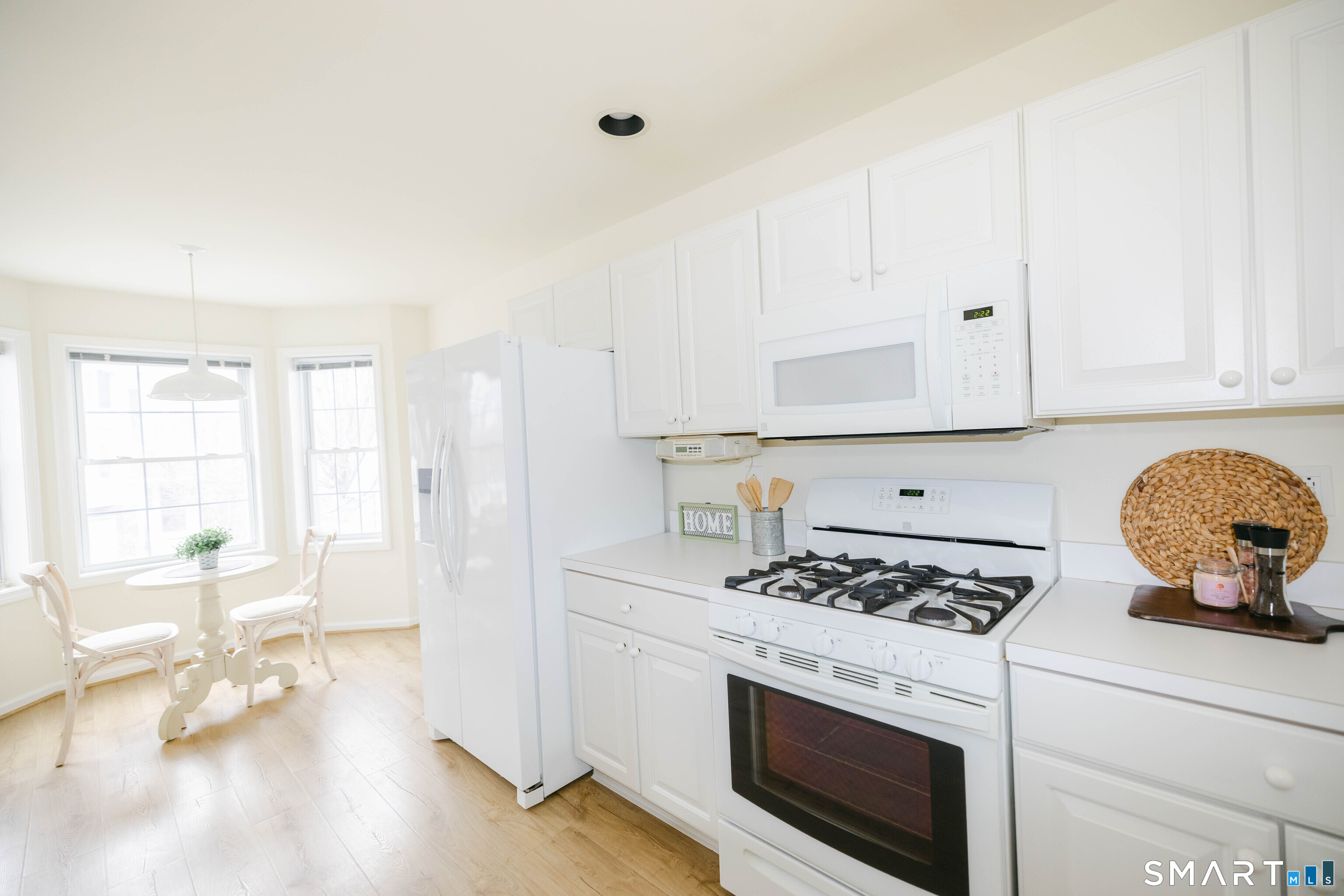 1502 Pinnacle Way, Unit 1502 Danbury, CT 06811 - Photo 4 of 45 a kitchen with granite countertop a stove a sink dishwasher and white cabinets with wooden floor