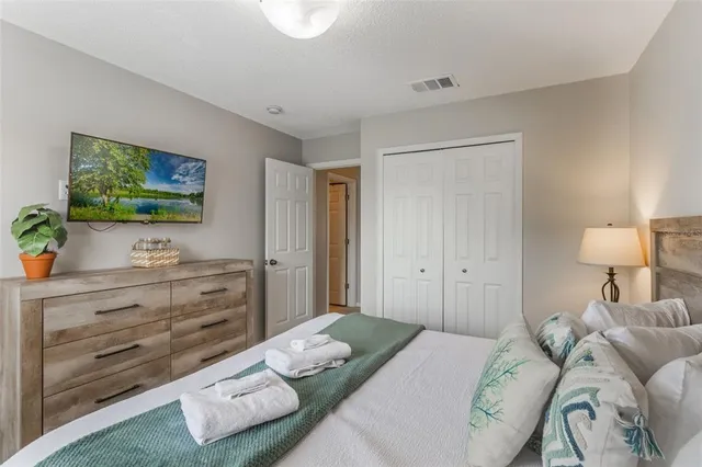 a bedroom with a bed and a flat screen tv