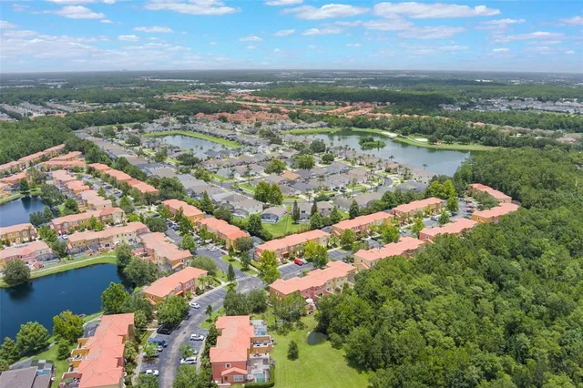 an aerial view of a city with lots of residential buildings ocean and mountain view in back