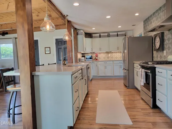 a kitchen with stainless steel appliances granite countertop a refrigerator and cabinets