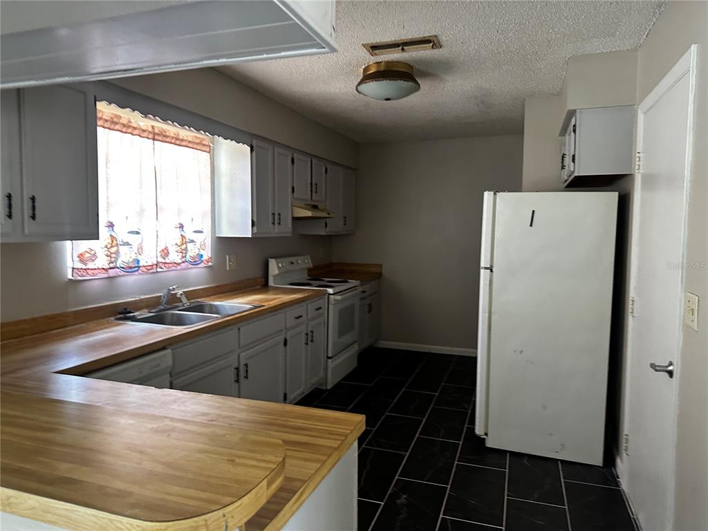 66 Silver Lane Ocala, FL 34472 - Photo 3 of 10 a kitchen with a sink a refrigerator and window