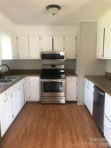 a kitchen with stainless steel appliances granite countertop a stove a sink and a refrigerator