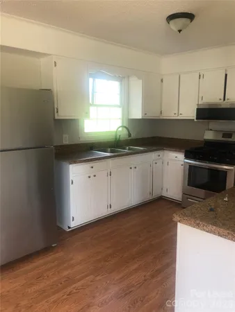 a kitchen with granite countertop a sink and a stove top oven