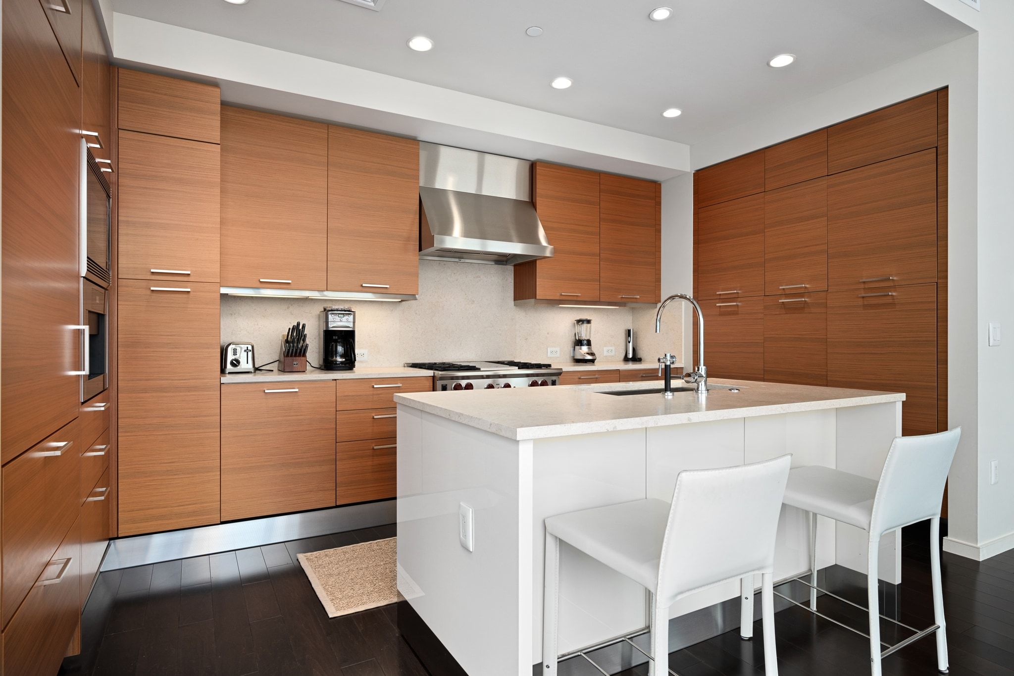 200 Congress Avenue, Unit 24E Austin, TX 78701 - Photo 12 of 40 a kitchen with a table chairs stove and cabinets