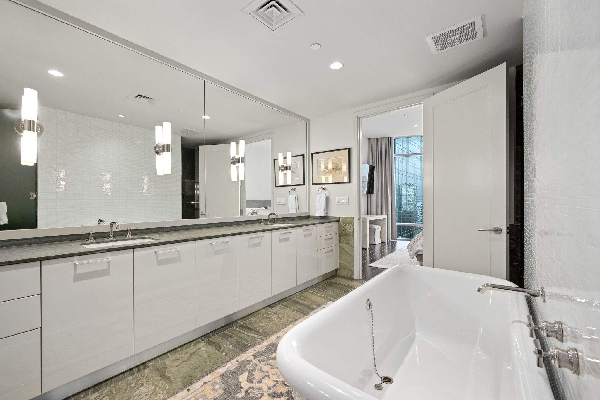 200 Congress Avenue, Unit 24E Austin, TX 78701 - Photo 19 of 40 a large white bathroom with a large tub a sink and shower