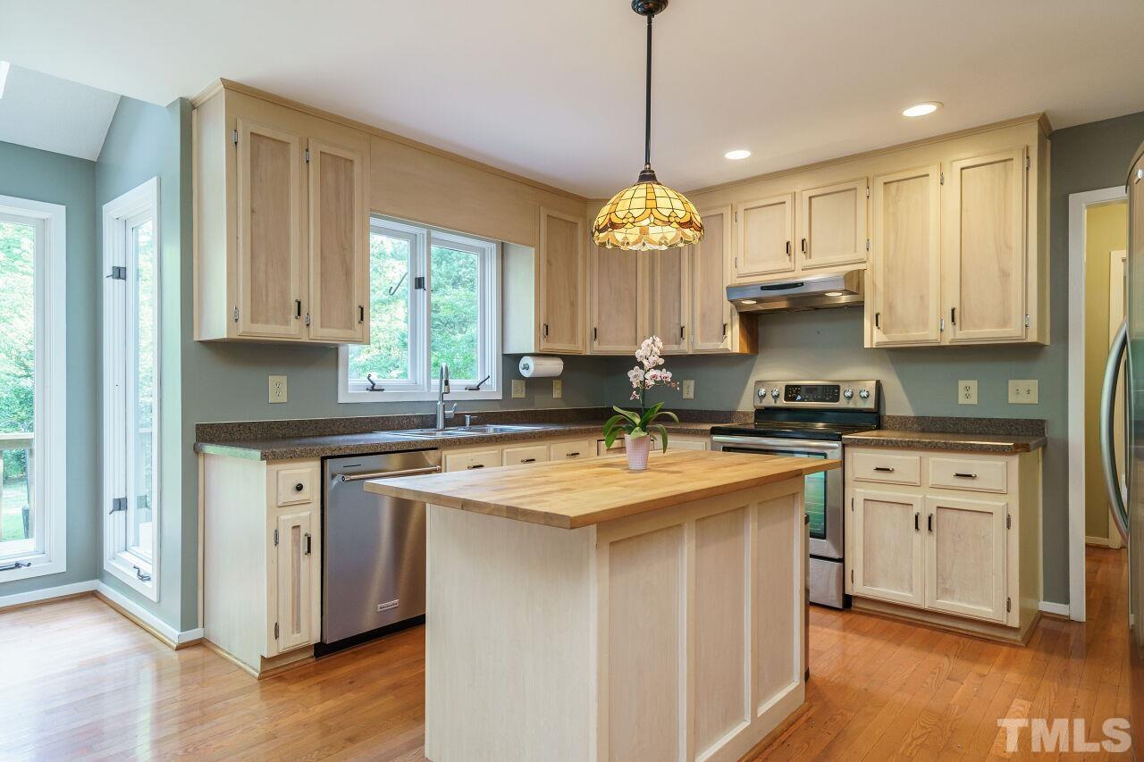 12213 Galway Drive Raleigh, NC 27613 - Photo 12 of 31 a kitchen with stainless steel appliances granite countertop a stove a sink dishwasher a refrigerator and white cabinets with wooden floor