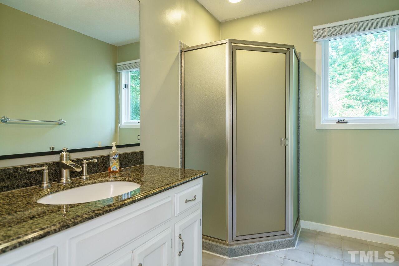 12213 Galway Drive Raleigh, NC 27613 - Photo 18 of 31 a bathroom with a granite countertop sink and a mirror