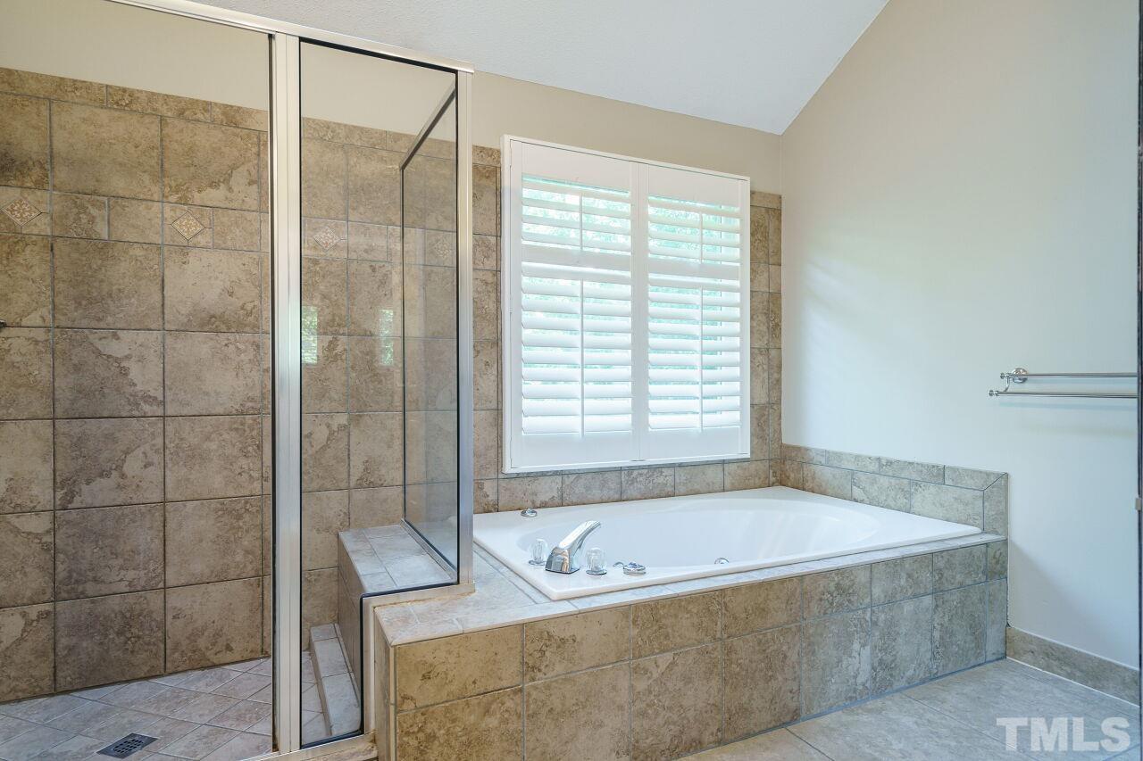 12213 Galway Drive Raleigh, NC 27613 - Photo 23 of 31 a bathroom with a tub and a shower