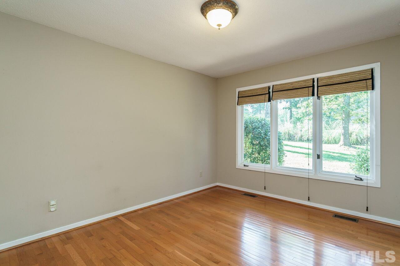 12213 Galway Drive Raleigh, NC 27613 - Photo 10 of 31 a view of an empty room with wooden floor and a window
