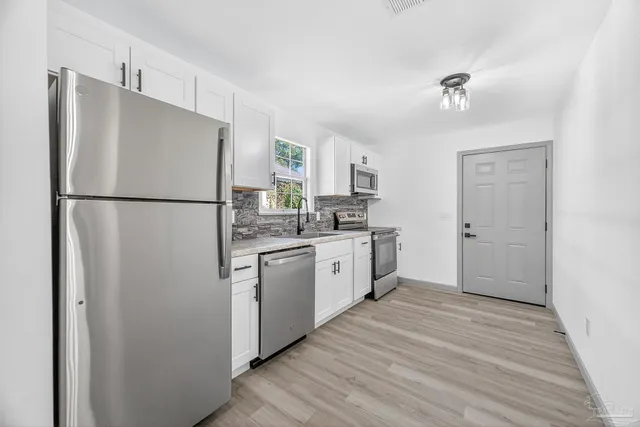 a kitchen with stainless steel appliances a refrigerator and a sink