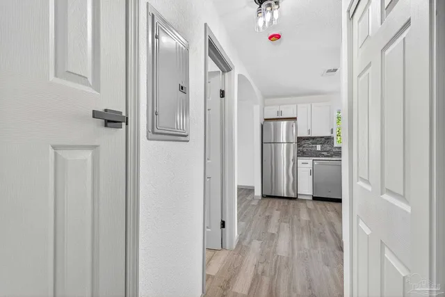 a kitchen with white cabinets and refrigerator