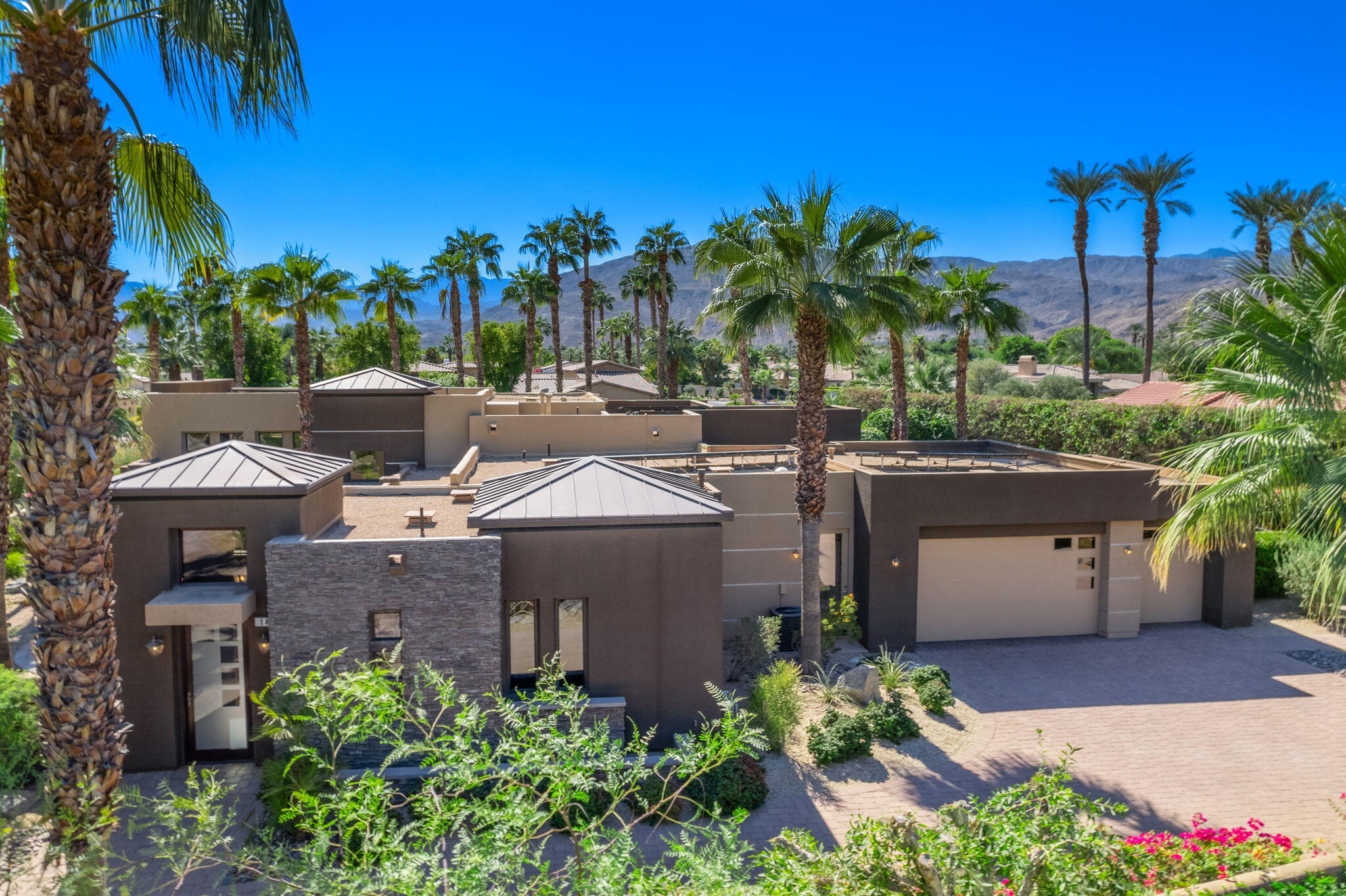 14 Dominion Court Rancho Mirage, CA 92270 - Photo 2 of 65 a view of a house with a yard and a garage