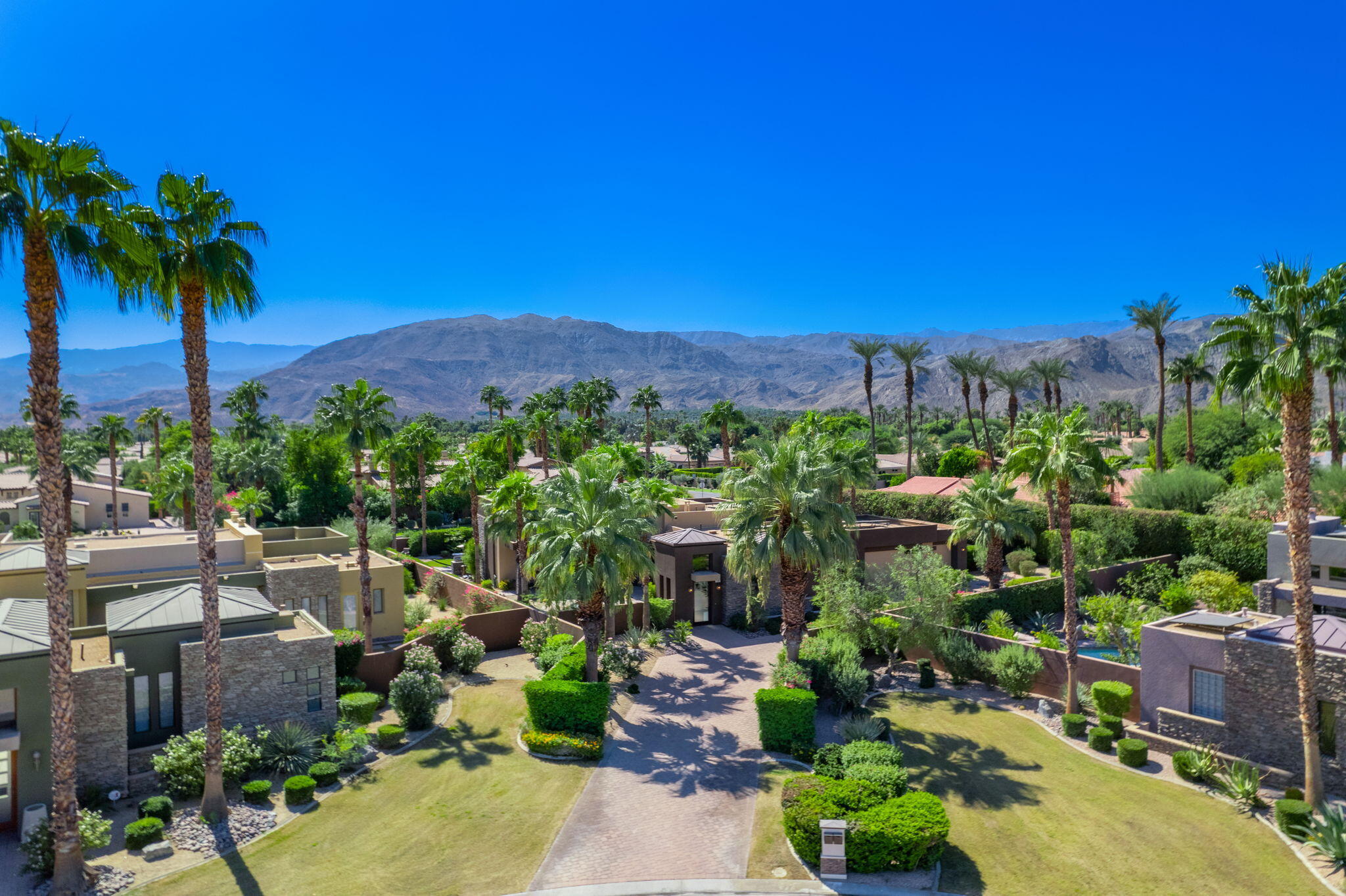 14 Dominion Court Rancho Mirage, CA 92270 - Photo 3 of 65 a view of a garden with a building in the background