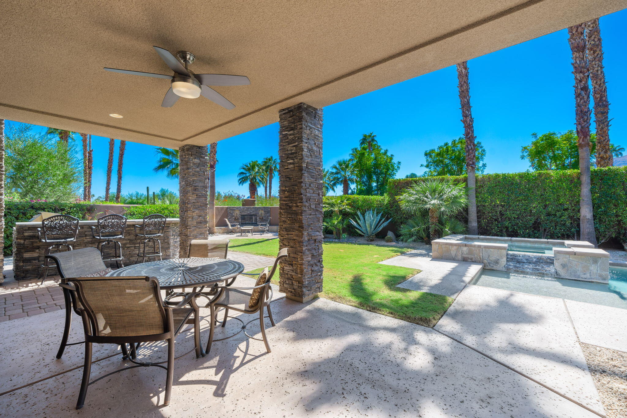 14 Dominion Court Rancho Mirage, CA 92270 - Photo 59 of 65 a view of a patio with a dining table and chairs with a small yard