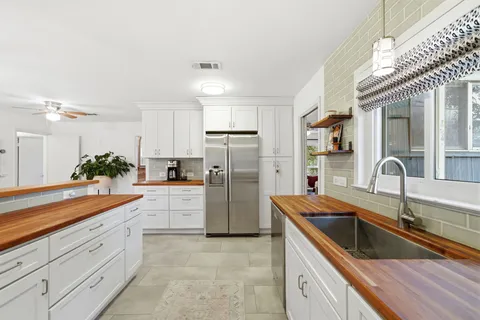 a kitchen with a sink a counter top stainless steel appliances and cabinets