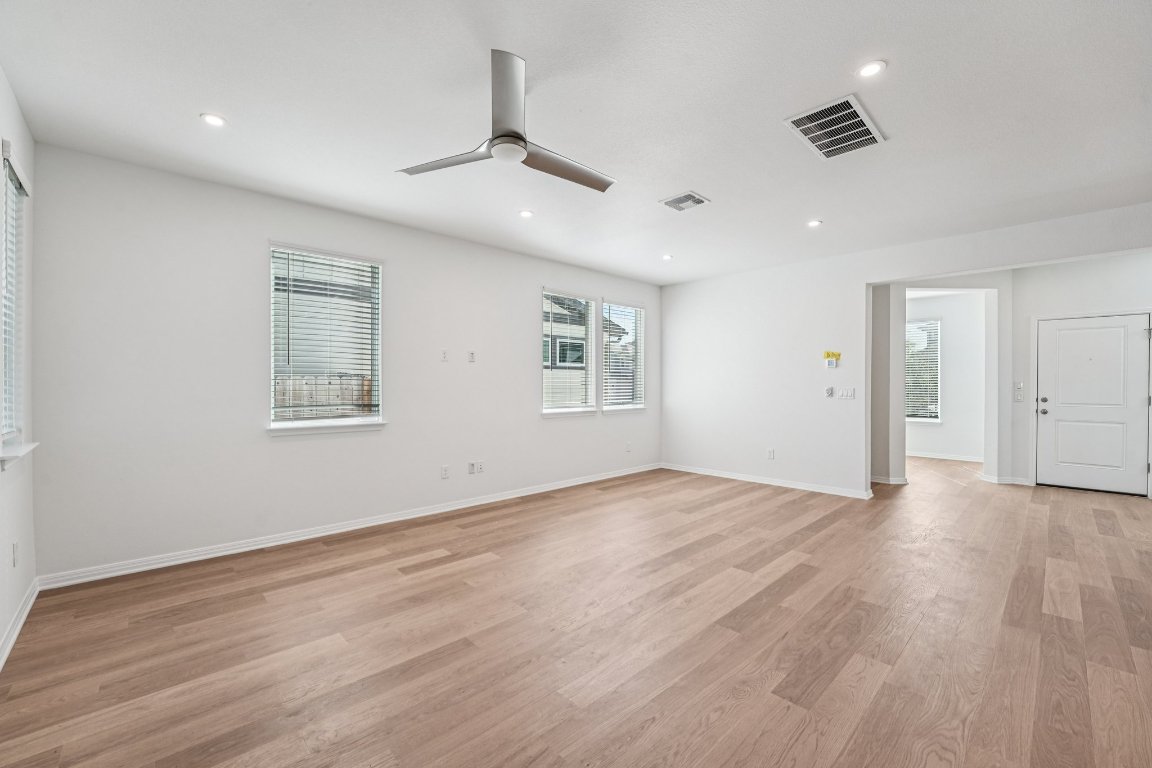 6309 Marsh Lane Buda, TX 78610 - Photo 12 of 39 a view of an empty room with wooden floor and a ceiling fan